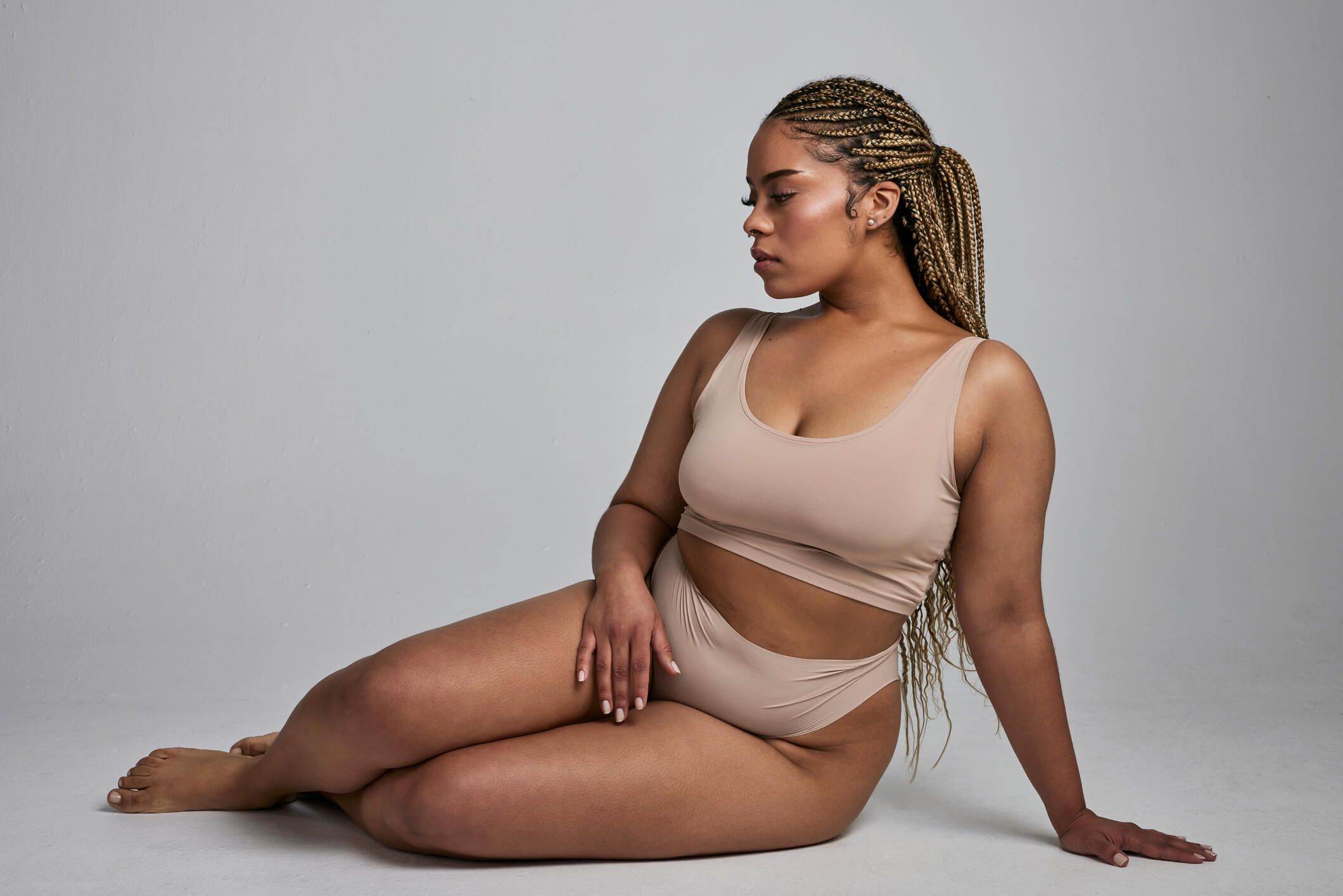 Model poses confidently in stylish nude swimwear.